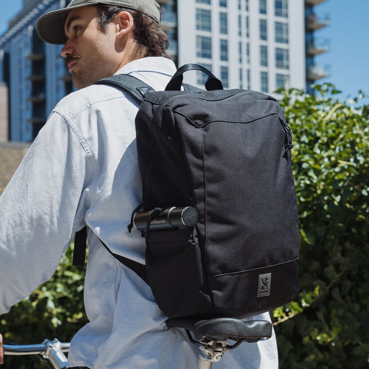 Black CHROME Recruit backpack worn outdoors with a U-lock in its side pocket.