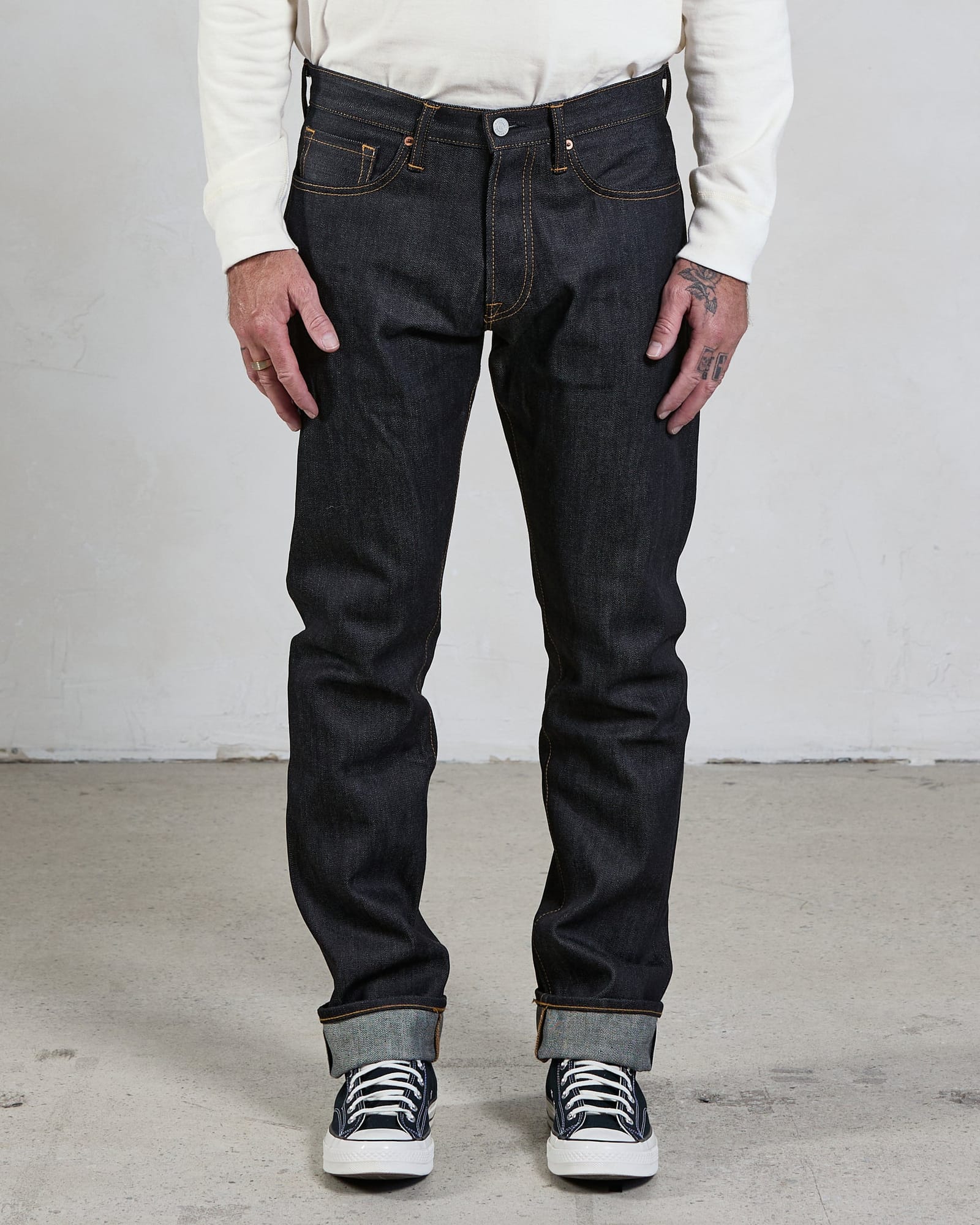Straight-cut Indigo jeans worn with the full leg silhouette visible.