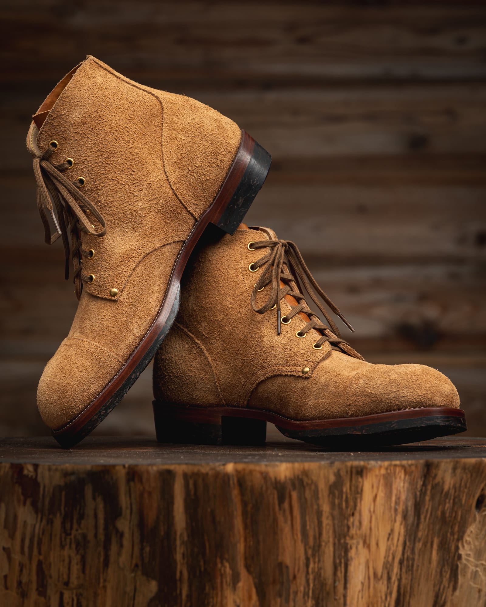 Two light-brown Infantry boots arranged on a stump, showing the capped toe and roughout leather.