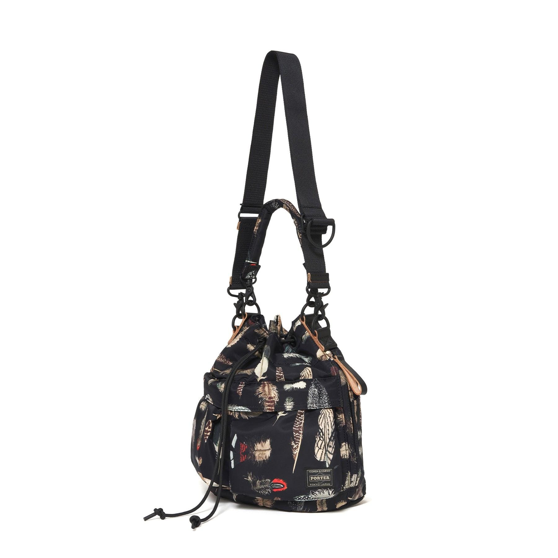 Black feather-print Tool Bag shown with its detachable longer strap, side view.