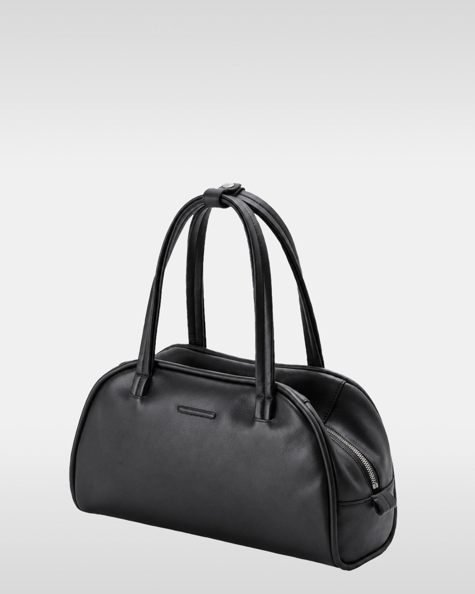 Angled view of the black Medium bag showing zip and twin handles.