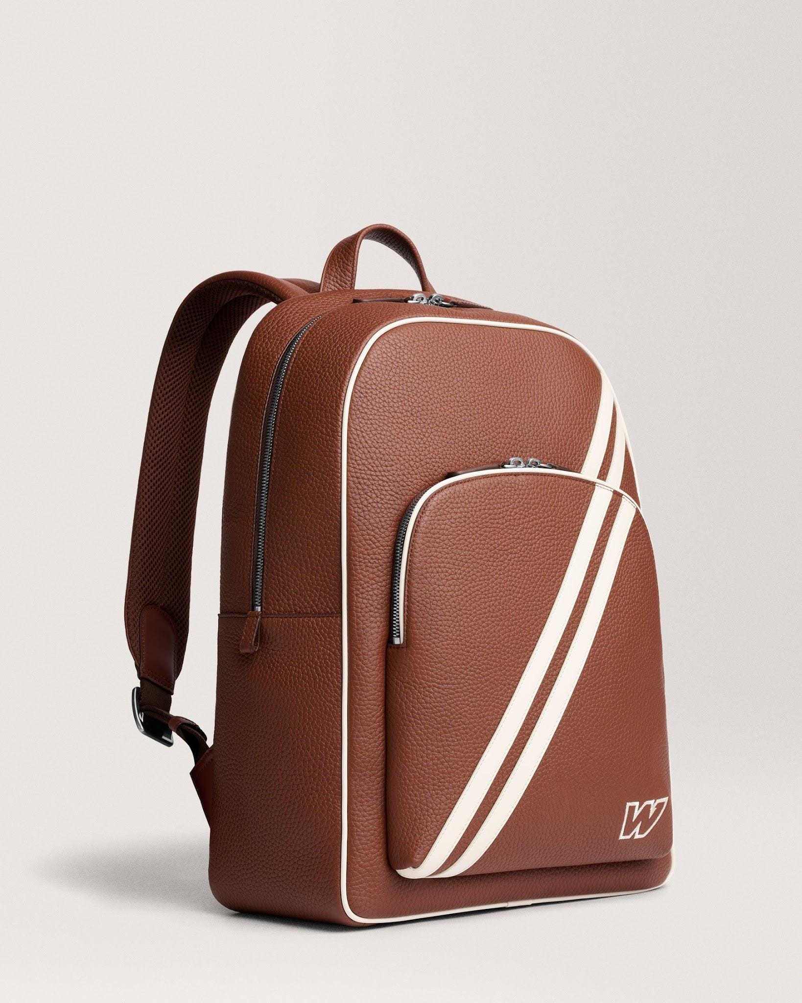 Angled backpack front showing the cream diagonal racing stripe.