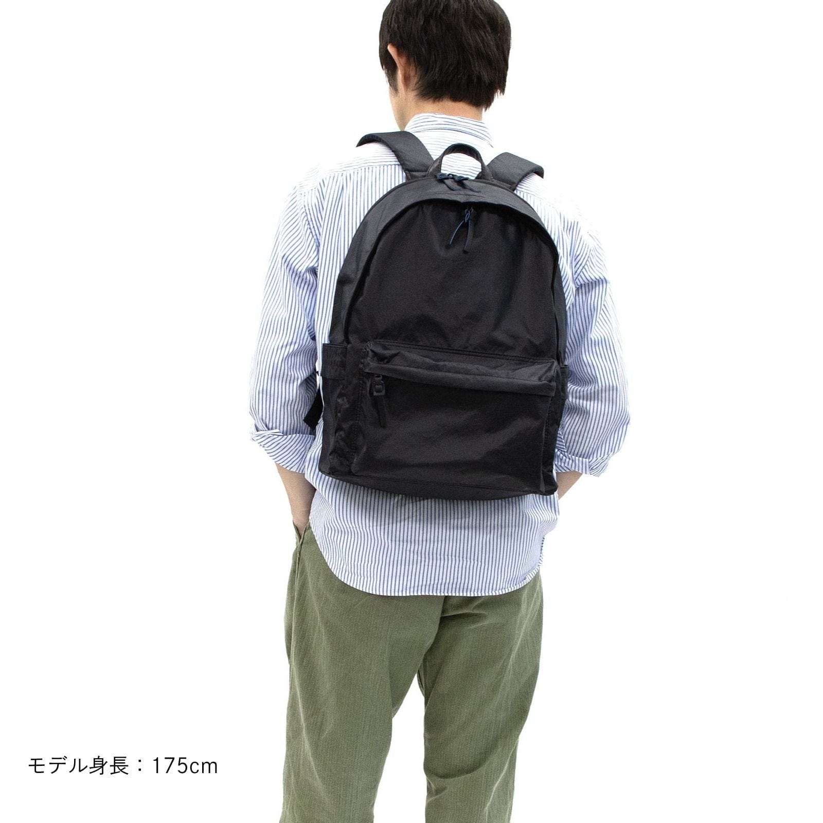 Model wearing black Float Daypack, rear view