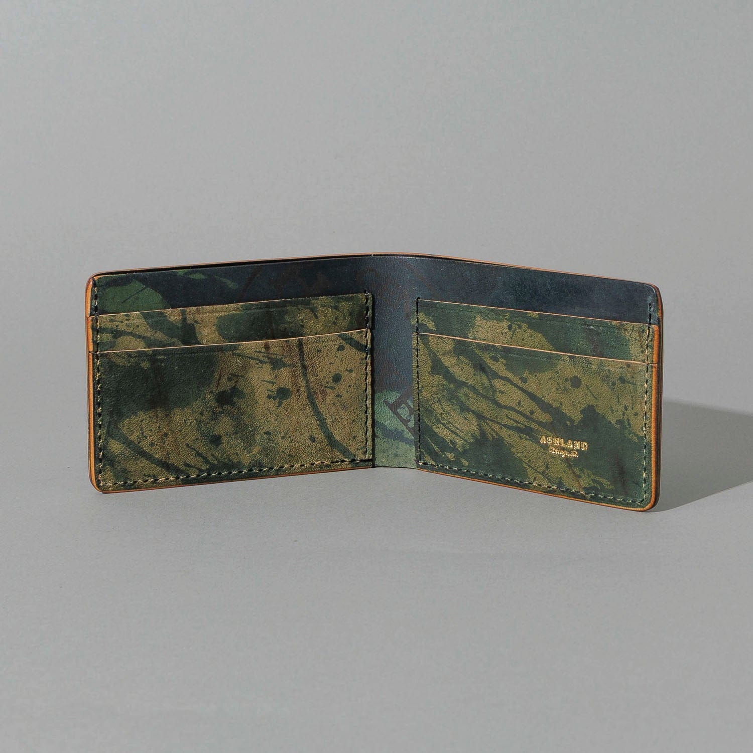 Open green-finish leather bifold from the fall-release preview