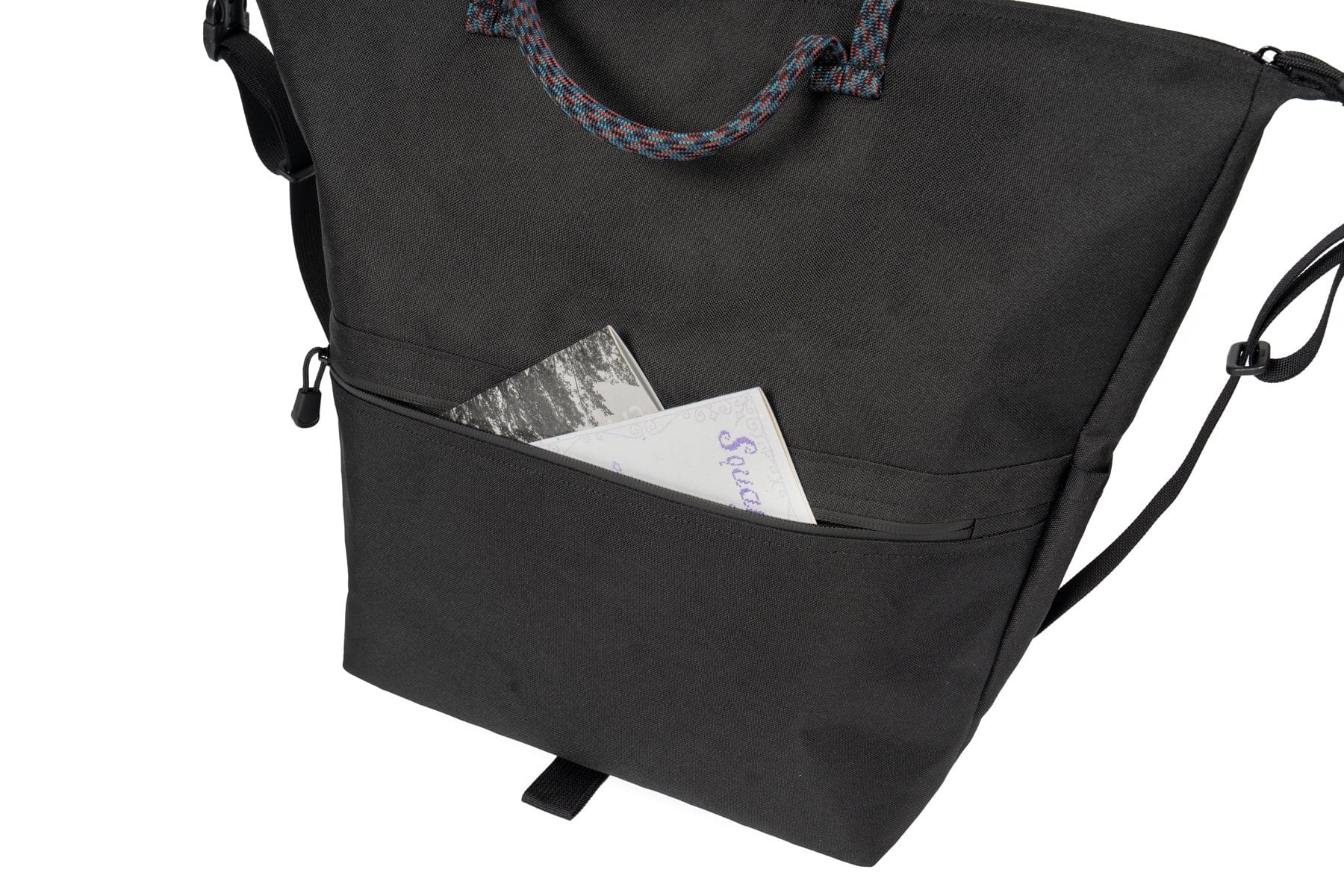Exterior sleeve pocket on the Outer Shell QR Tote holding a small item.