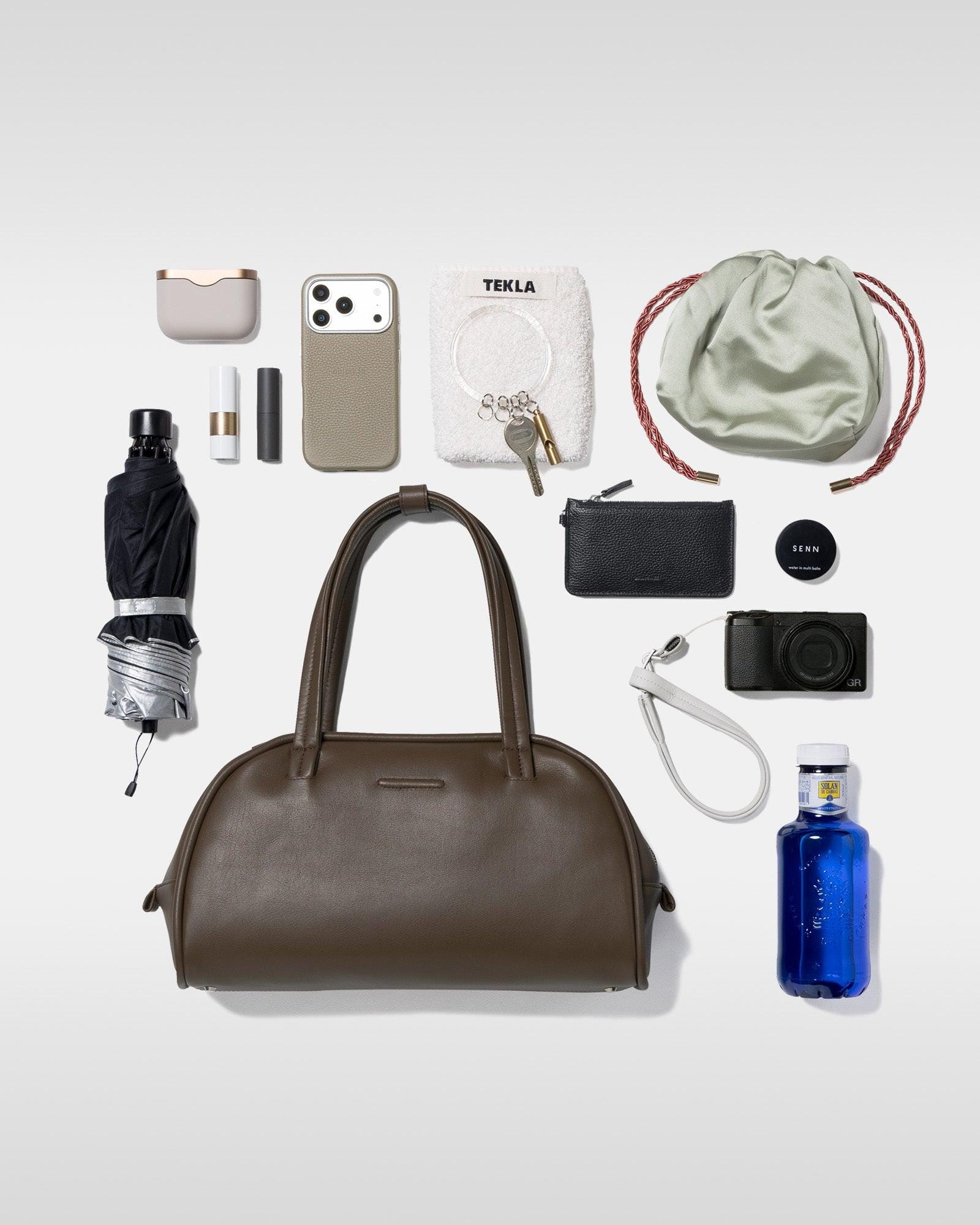 Contents laid out beside the brown Boston Medium to illustrate carrying volume.