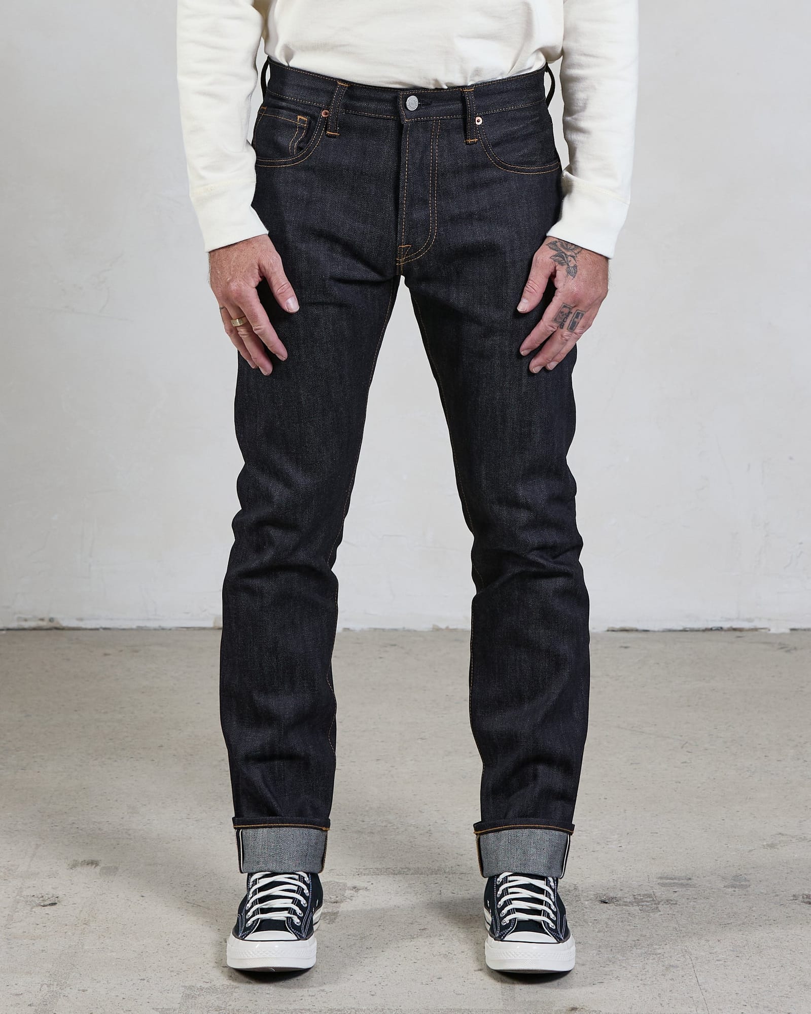 Slim-cut Indigo jeans worn with the leg silhouette visible.