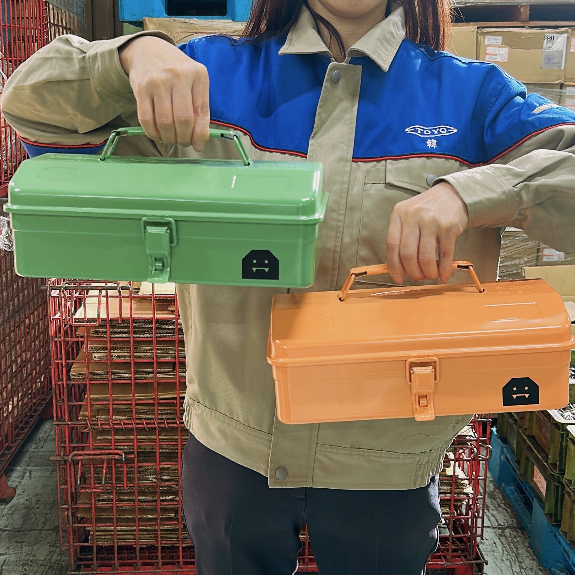Person holding TOYO STEEL Y-280 Halloween toolboxes in Pumpkin Orange and Franken Green.