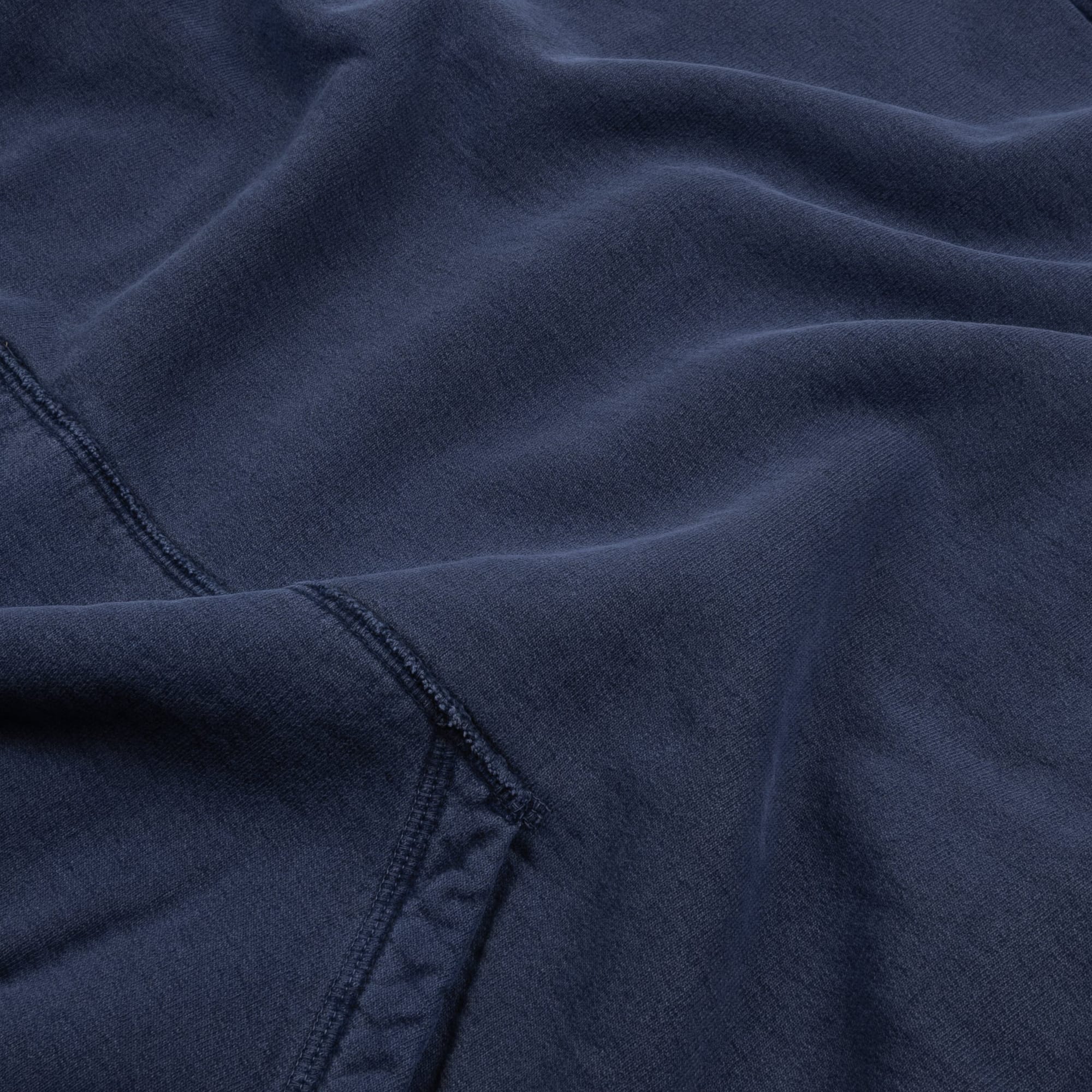 Close view of the navy cotton fleece surface and pocket seam.