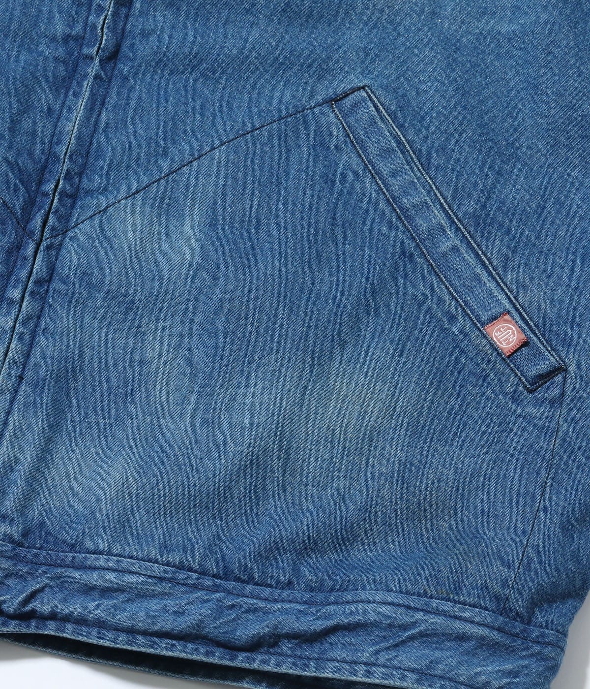 Angled lower pocket in faded denim