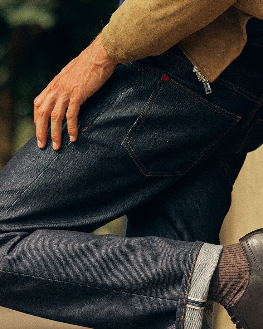Hiut Super Zero Indigo campaign detail showing seated jeans, pocket stitching and turned cuff.