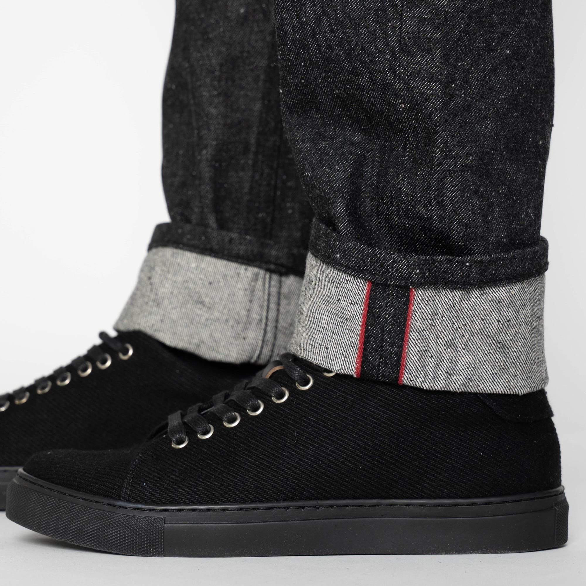 Turned-up cuff showing the red selvedge edge and contrasting reverse of the denim.