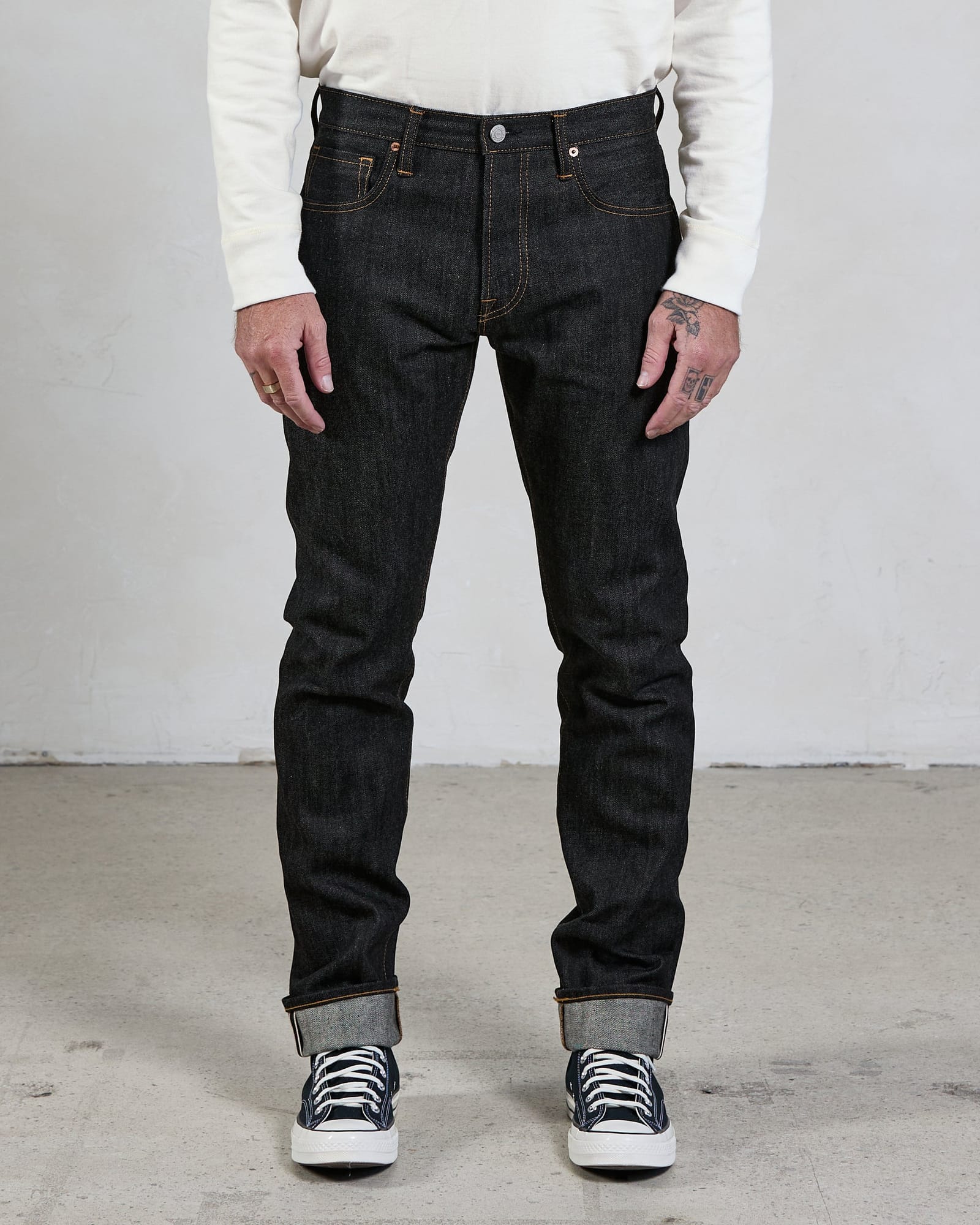Slim-cut Indigo Black jeans worn with the leg silhouette visible.