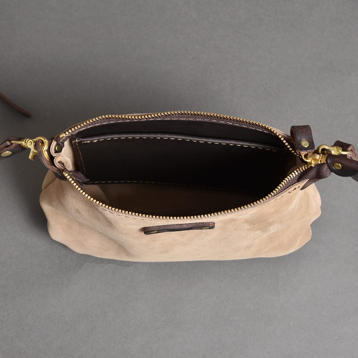 Open zipped top and interior of the HERZ SUB2604 suede shoulder bag.