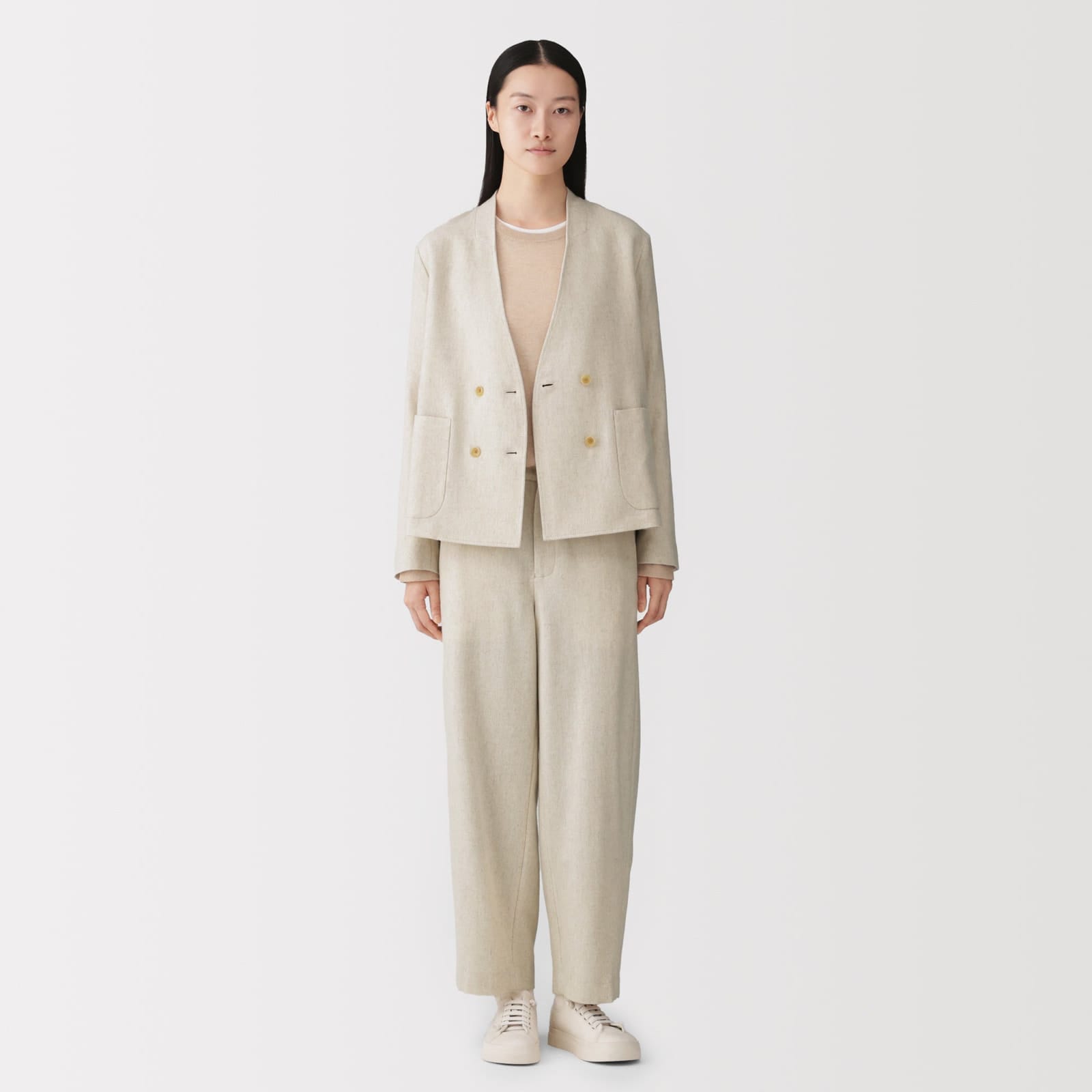 Model wearing an ivory MUJI Labo jacket with matching pale trousers