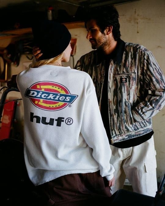 HUF and Dickies campaign photograph showing a white thermal top and camouflage jacket.