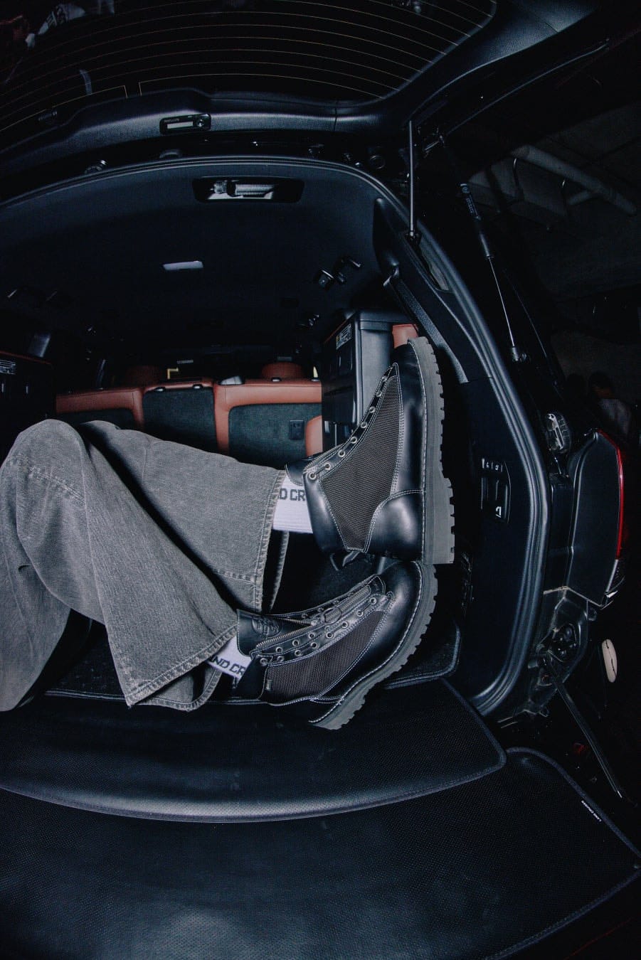 Black Danner Field R Urban boots worn inside the rear opening of a dark vehicle.