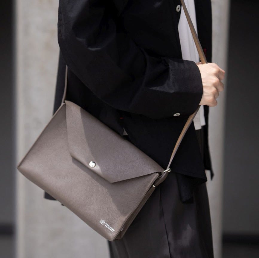 A grey Kawanishi Dual Letter shoulder bag worn across the body.