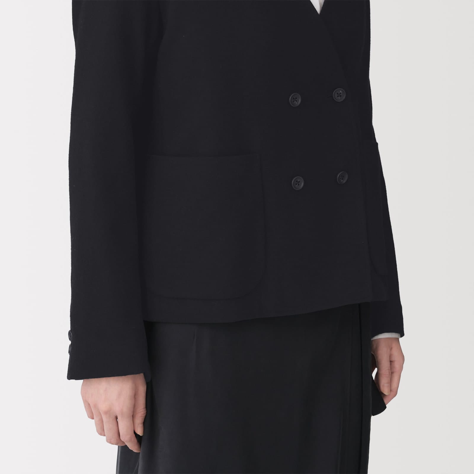 Close-up of the black jacket’s four-button front and patch pocket