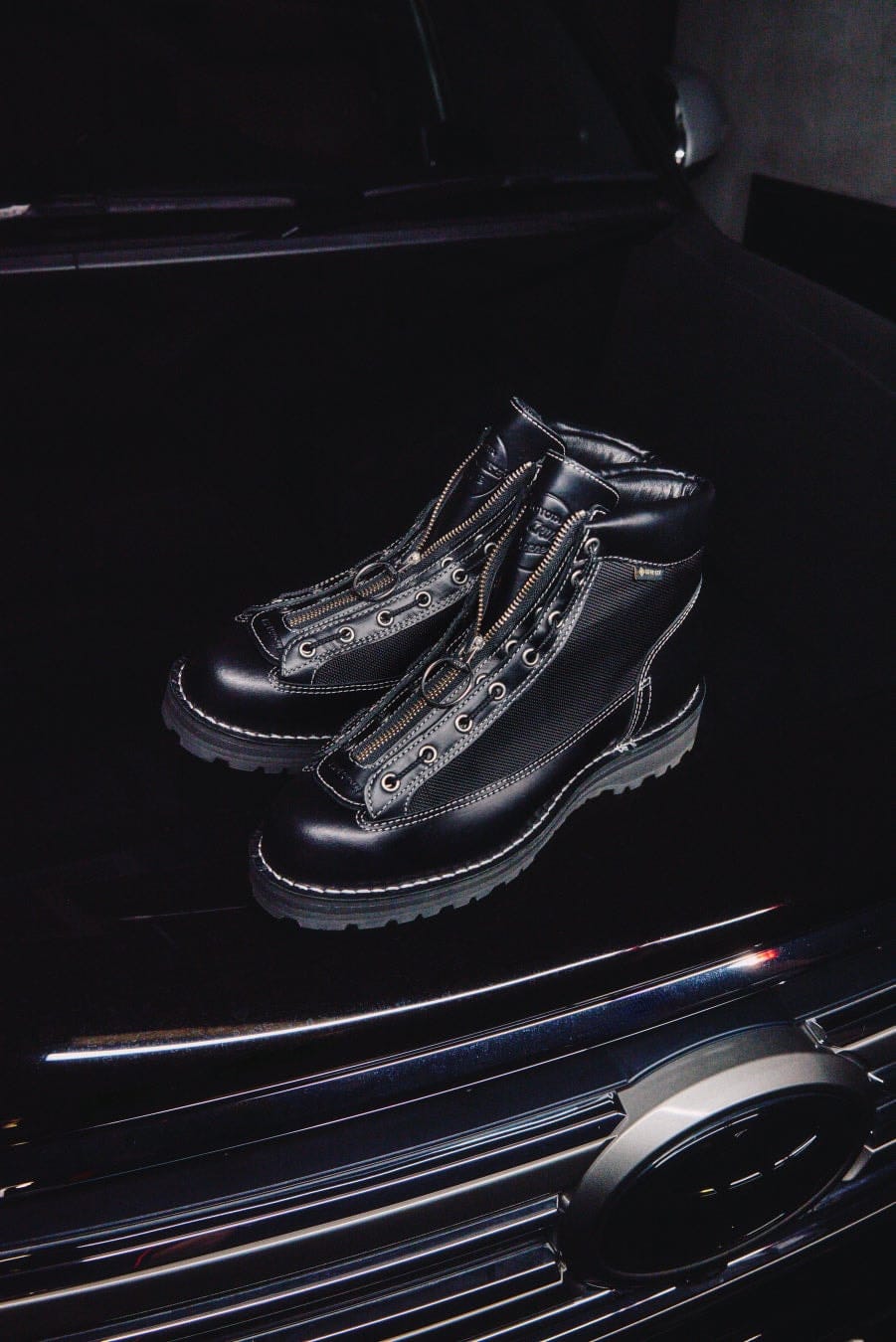 A pair of black Danner Field R Urban boots photographed in a vehicle doorway.