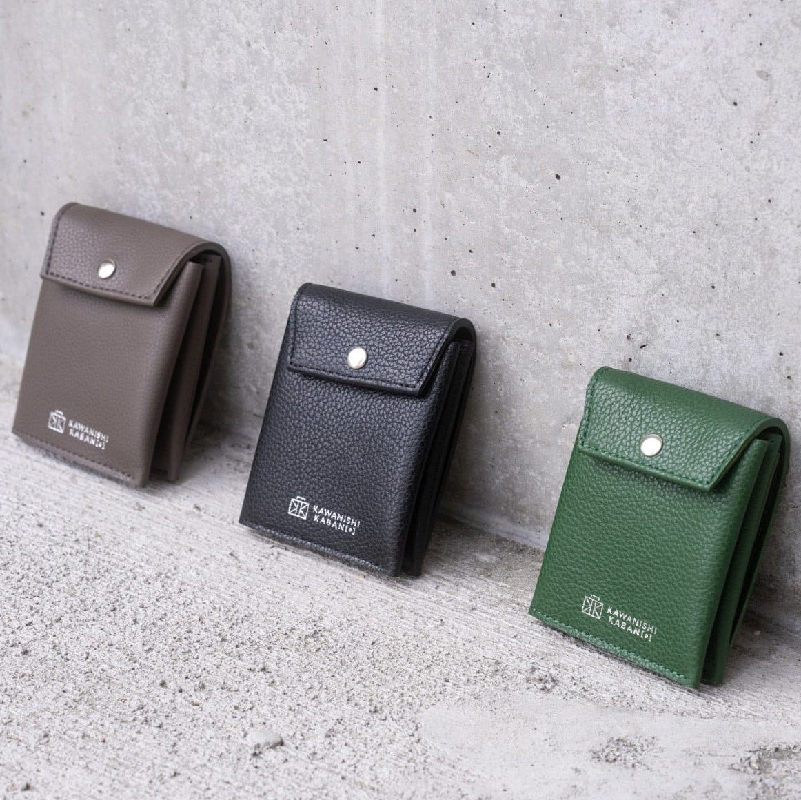 Three Kawanishi Dual Hand wallets in grey, black and green.
