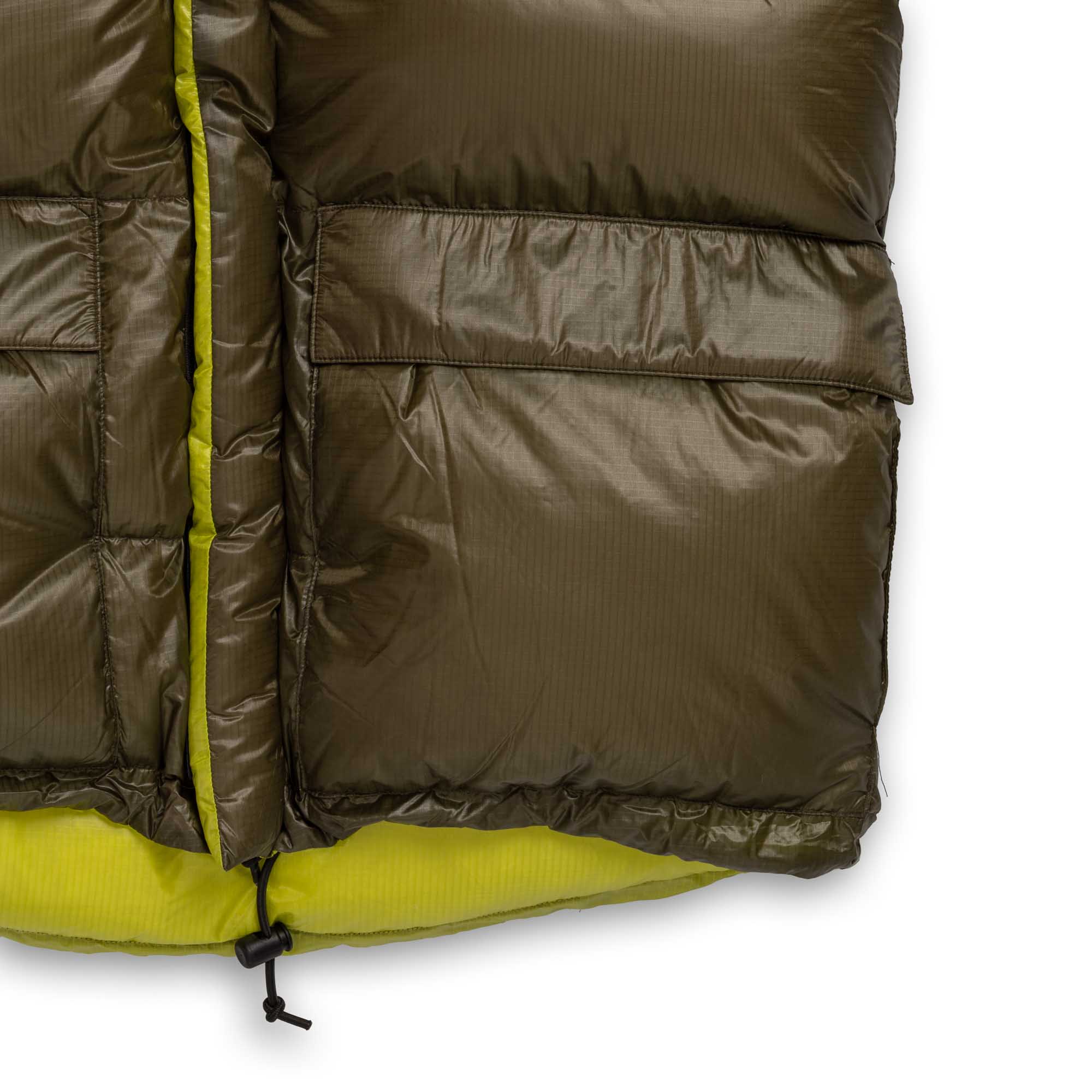 Detail of the parka’s lower front pocket, bright lining and hem drawcord.