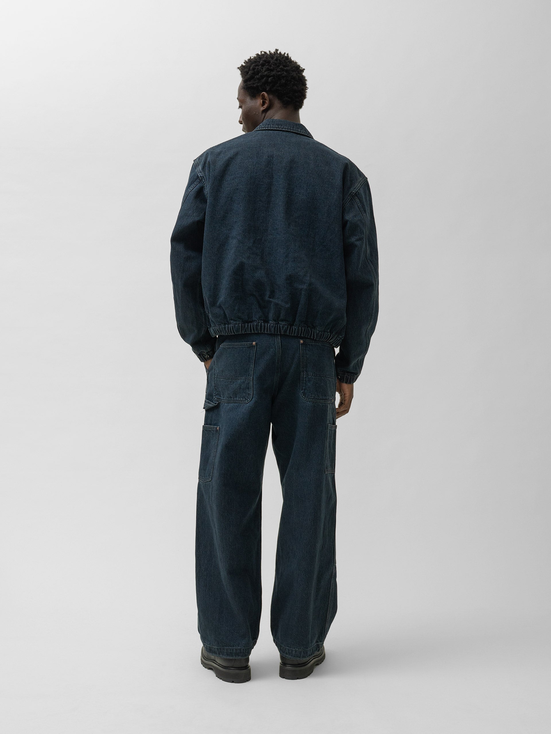 Rear view of a model wearing the denim work blouson.
