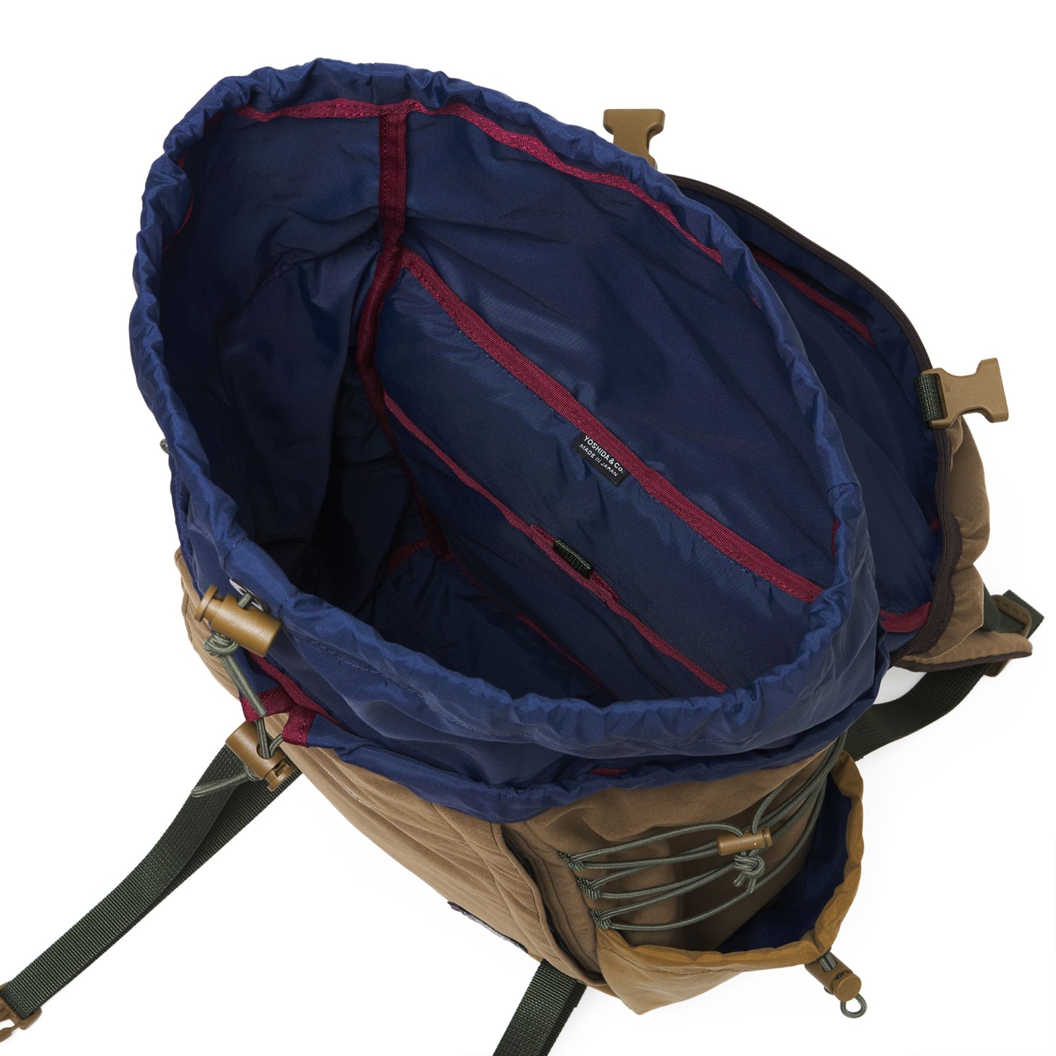 View into the navy-lined backpack showing the internal sleeve, burgundy binding and Yoshida & Co. label.